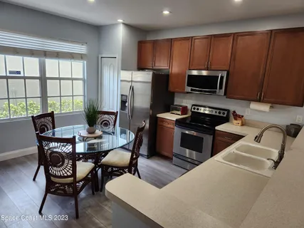a kitchen with a table chairs refrigerator and microwave
