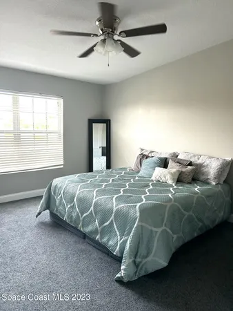 a bed sitting in a bedroom next to a window
