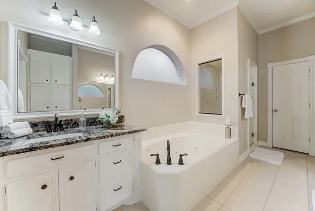 a bathroom with a tub sink and mirror