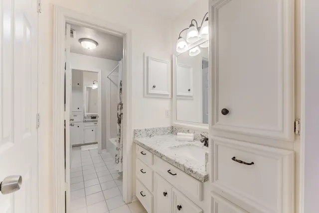 a bathroom with a granite countertop sink mirror and shower