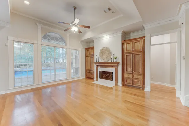 a view of a livingroom with a fireplace wooden floor and windows