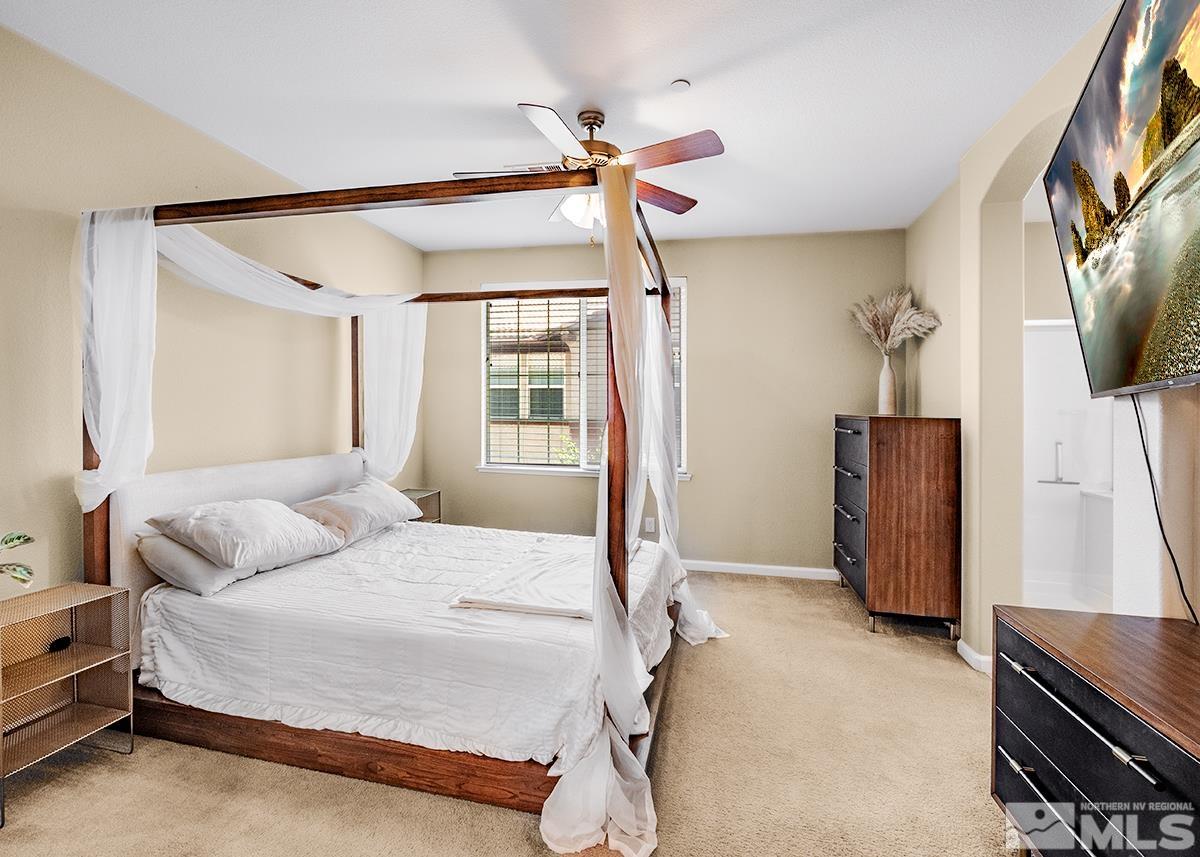 1865 Wind Ranch Road, Unit B Reno, NV 89521 - Photo 17 of 26 a bedroom with a bed flat screen tv and a window