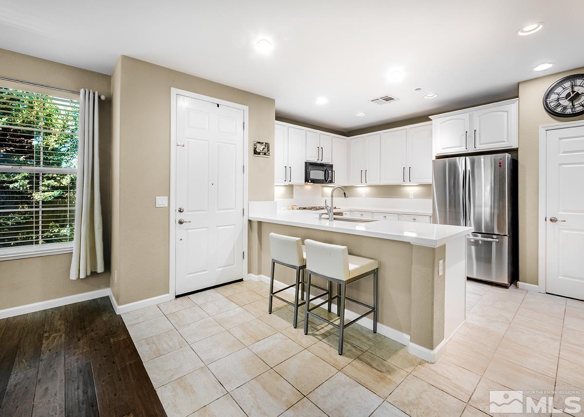 1865 Wind Ranch Road, Unit B Reno, NV 89521 - Photo 8 of 26 a kitchen with refrigerator cabinets and wooden floor