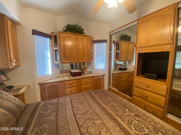 a large kitchen with a refrigerator and wooden floor