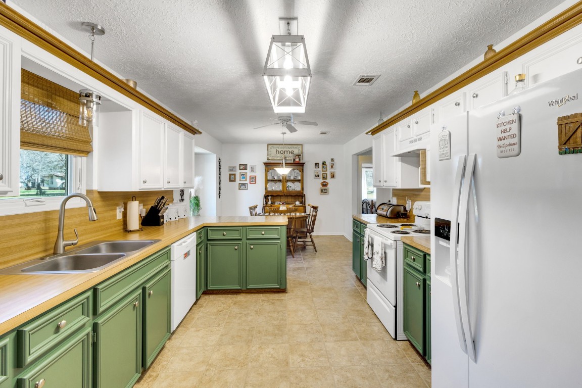 144 Thornton Road Trinity, TX 75862 - Photo 15 of 39 a kitchen with stainless steel appliances granite countertop a refrigerator a sink dishwasher a oven with white cabinets and wooden floor