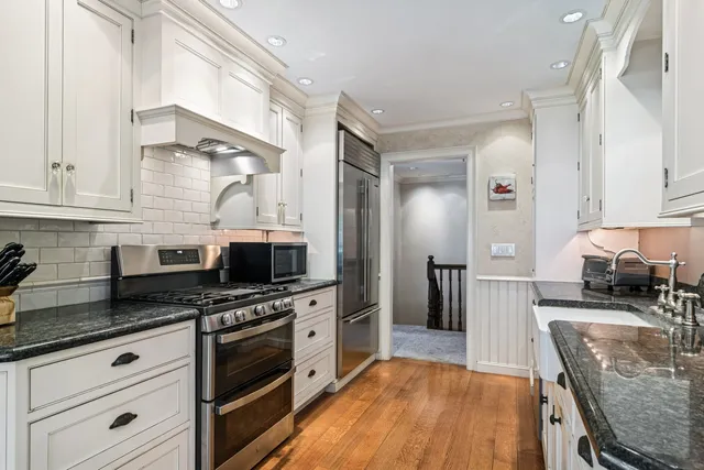 a kitchen with stainless steel appliances a stove a sink and a microwave