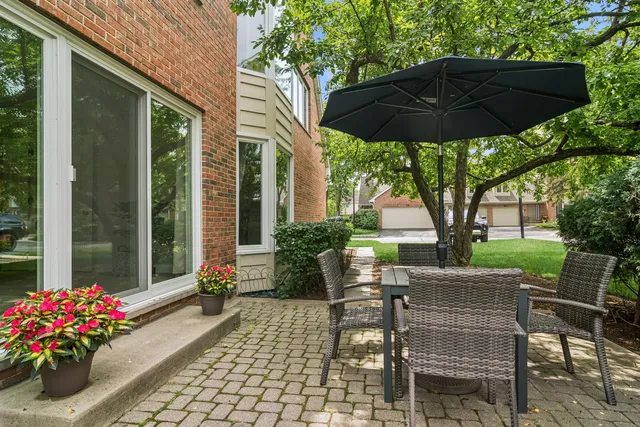 a view of a patio with table and chairs under an umbrella