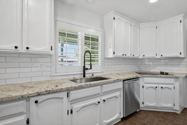 a kitchen with granite countertop a sink and cabinets