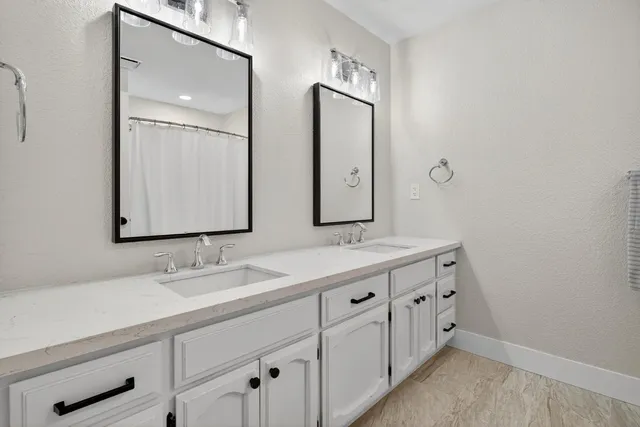 a bathroom with double vanity sink and a mirror