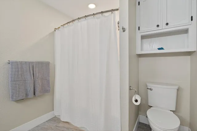 a bathroom with a toilet and a shower curtain