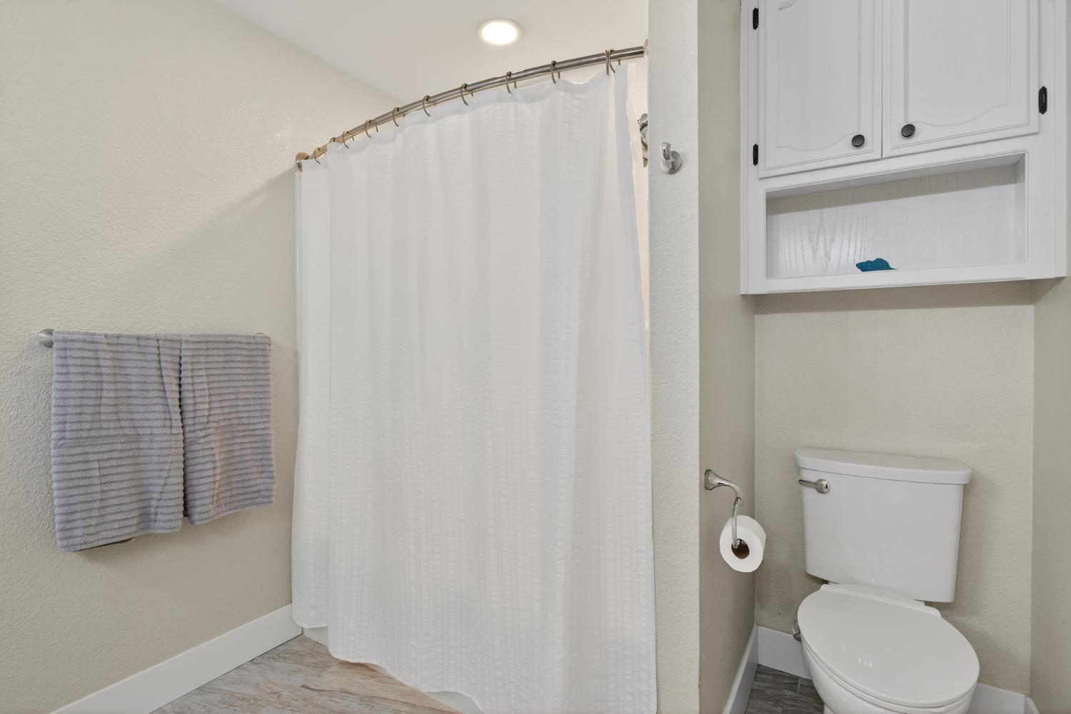 2325 Rio Verde Drive Riverbank, CA 95367 - Photo 25 of 43 a bathroom with a toilet and a shower curtain
