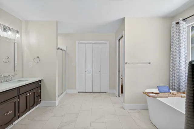a bathroom with a tub sink toilet and mirror