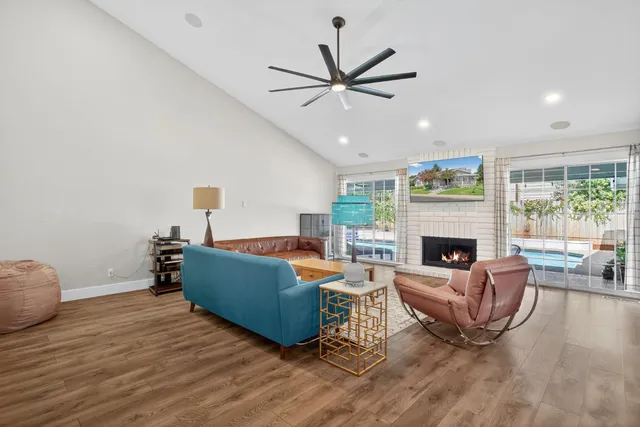 a living room with furniture a fireplace and a large window