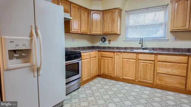 a kitchen with granite countertop white cabinets and stainless steel appliances