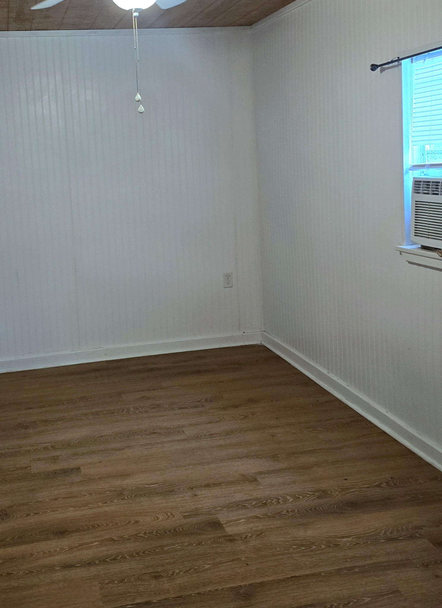 369 East Chestnut Avenue Winnie, TX 77665 - Photo 9 of 20 a view of an empty room with wooden floor and a window