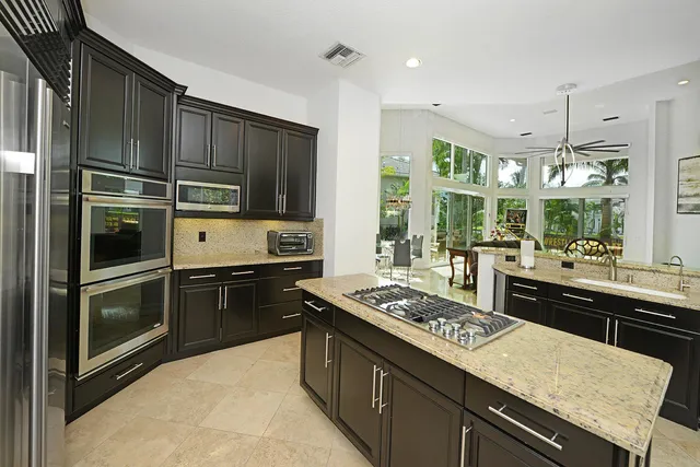 a kitchen that has a kitchen island wooden cabinets and refrigerator