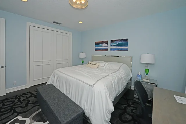 a bedroom with a bed and a dresser next to a window