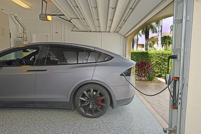 a view of a house with a yard and coconut trees
