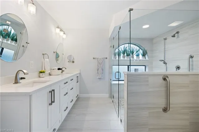 a bathroom with a double vanity sink mirror and shower