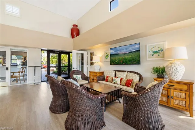 a living room with furniture a flat screen tv and kitchen view