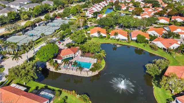 an aerial view of a house with a yard and lake view
