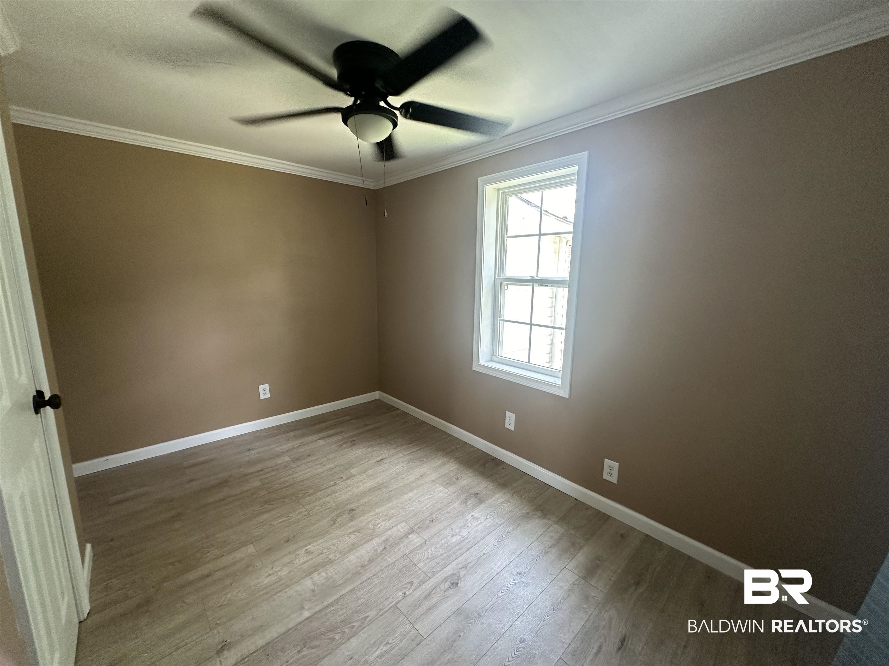 1600 Woods Road Atmore, AL 36502 - Photo 9 of 20 Unfurnished room with ceiling fan, crown molding, and hardwood / wood-style flooring