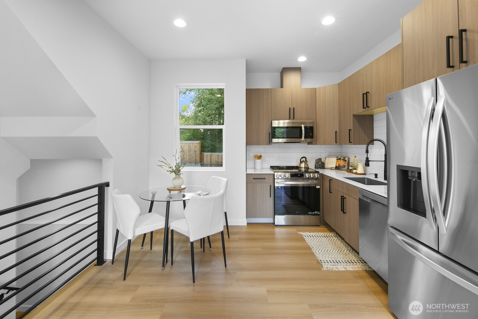 2805 South Grand Street Seattle, WA 98144 - Photo 6 of 31 a kitchen with stainless steel appliances a refrigerator a stove a sink a dining table and chairs with wooden floor