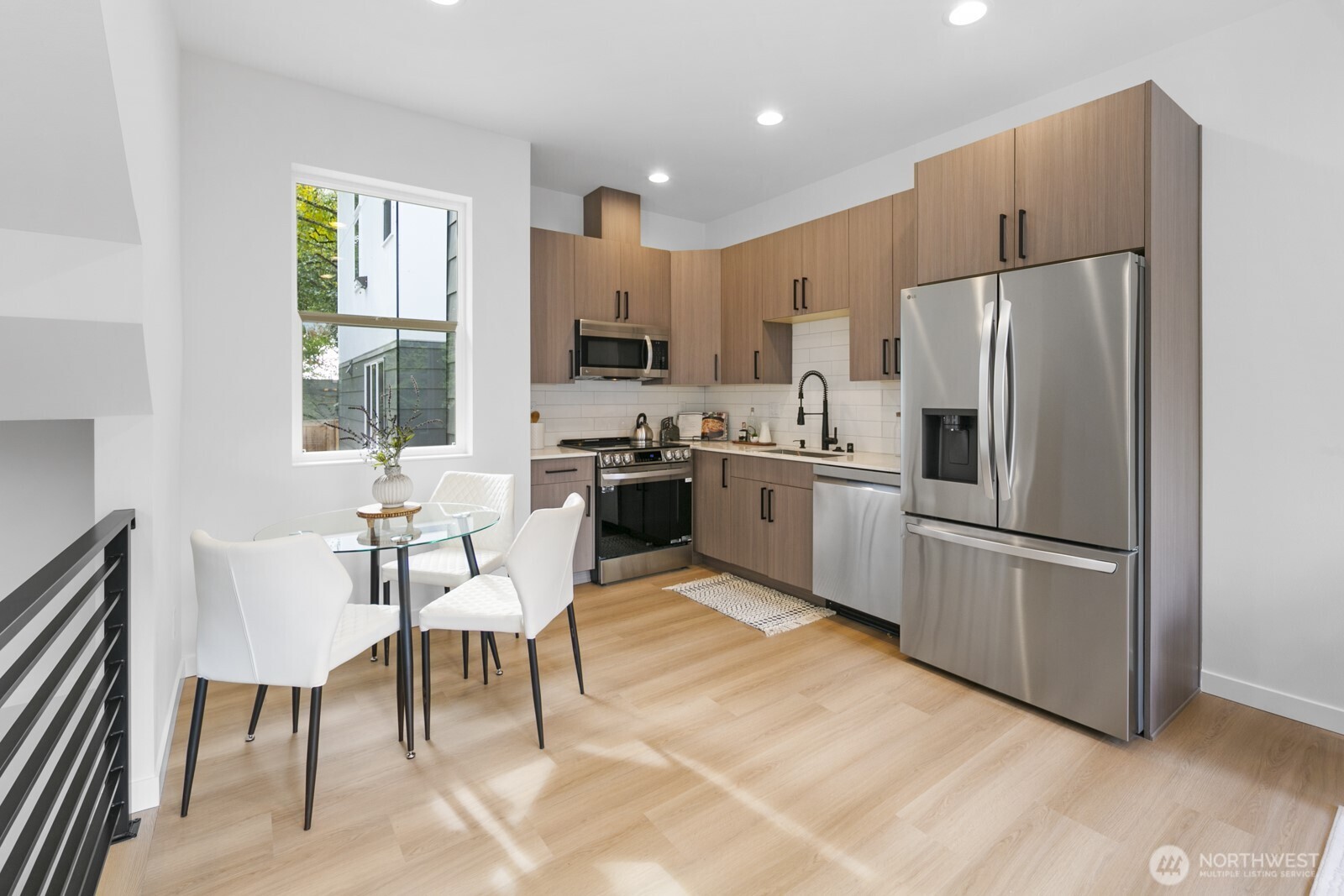 2805 South Grand Street Seattle, WA 98144 - Photo 7 of 31 a kitchen with stainless steel appliances granite countertop a refrigerator a stove a sink dishwasher a dining table and chairs with wooden floor