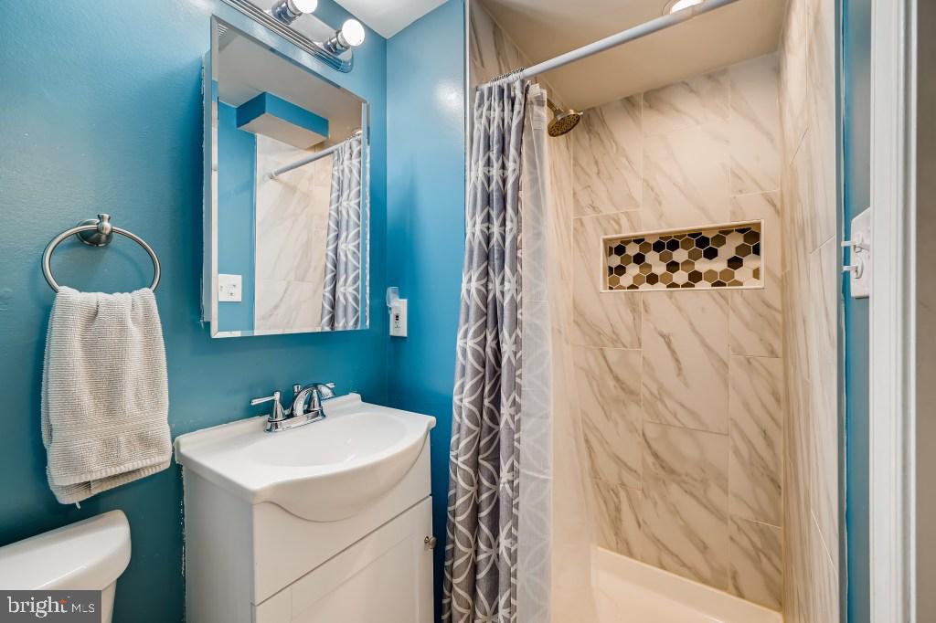 8023 Wallace Road Baltimore, MD 21222 - Photo 14 of 21 a bathroom with a sink and mirror with toilet