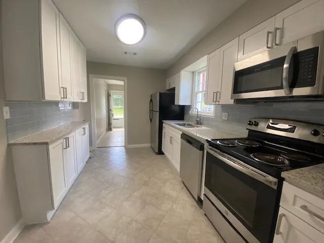 a kitchen with stainless steel appliances a stove microwave sink and cabinets
