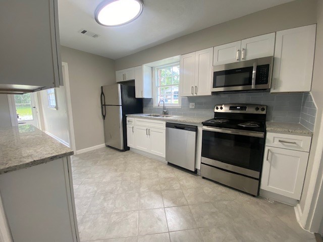 2802 King Street Columbus, GA 31906 - Photo 3 of 11 a kitchen with stainless steel appliances granite countertop a stove a sink and a microwave