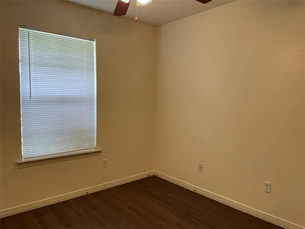 a view of a small space with wooden floor and a window