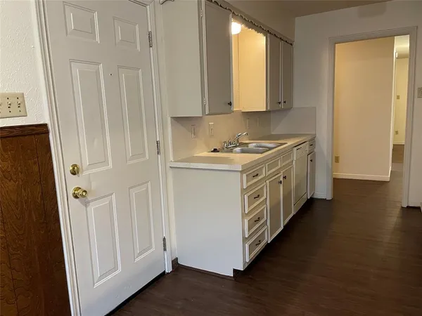 a kitchen with a white stove top oven and white cabinets