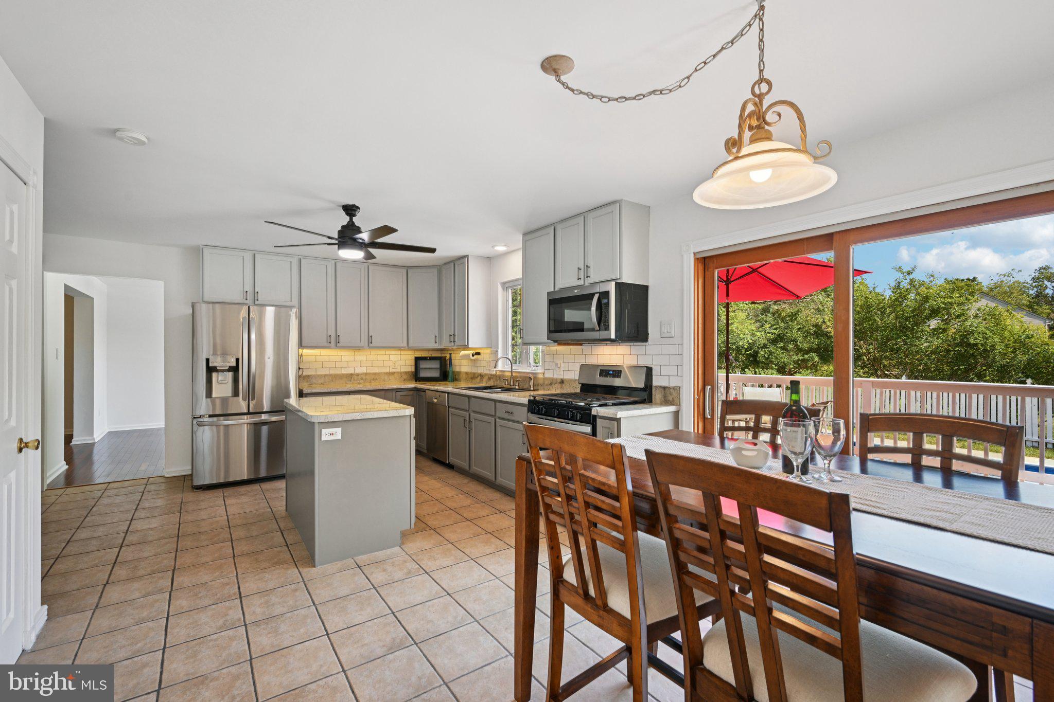 821 West Orvilla Road Hatfield, PA 19440 - Photo 15 of 64 a kitchen with stainless steel appliances granite countertop a stove top oven a sink dishwasher a dining table and chairs with wooden floor