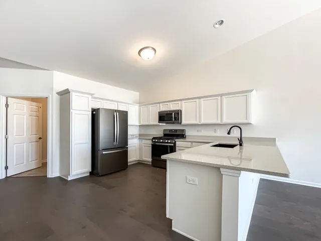 a kitchen with stainless steel appliances granite countertop a refrigerator a stove top oven a sink and dishwasher