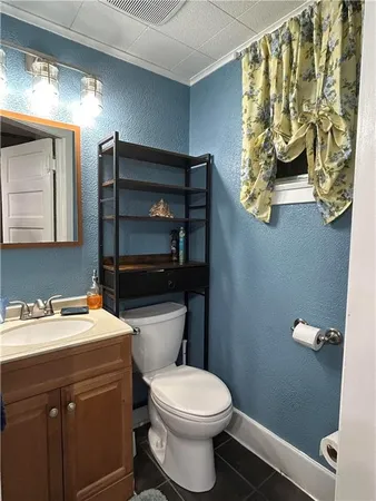 a bathroom with a toilet sink and mirror