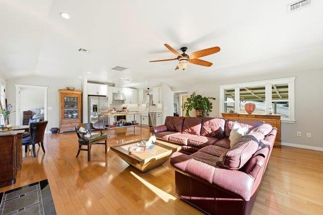 a kitchen with stainless steel appliances kitchen island granite countertop a stove a sink and a microwave