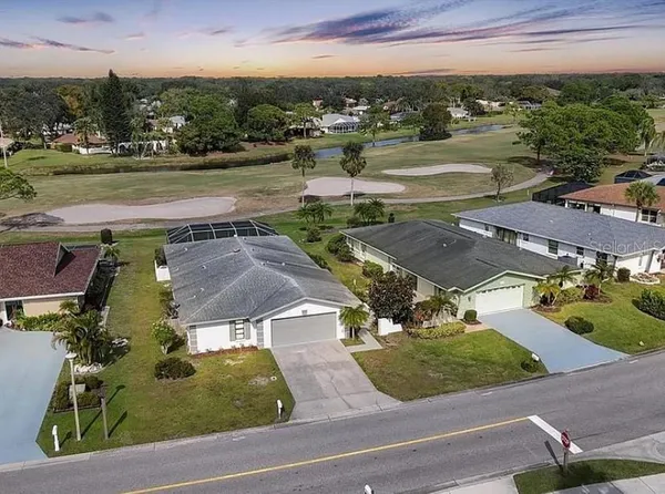 an aerial view of residential houses with outdoor space and parking