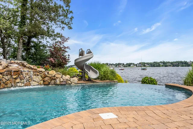 a living room with furniture a flat screen tv and a floor to ceiling window