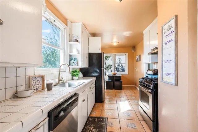 a kitchen with a sink a stove and cabinets