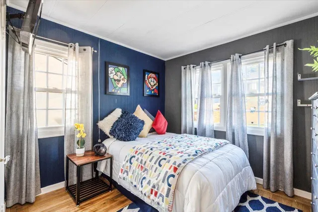 a bedroom with a bed and a painting on the wall