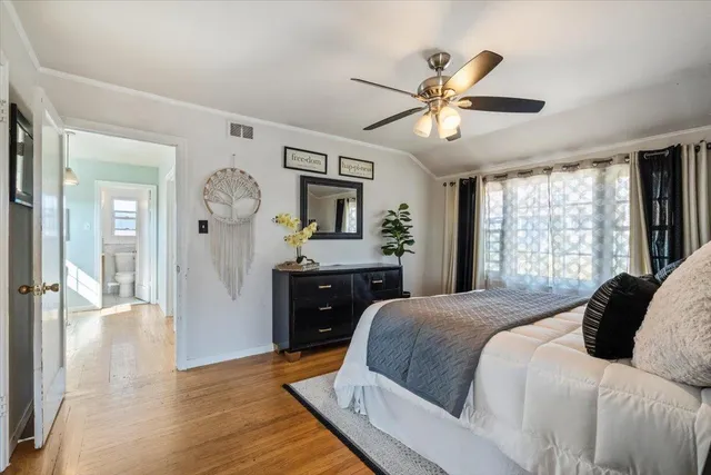 a bedroom with a large bed and wooden floor