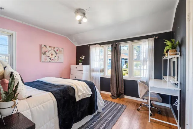 a bedroom with a bed and large windows