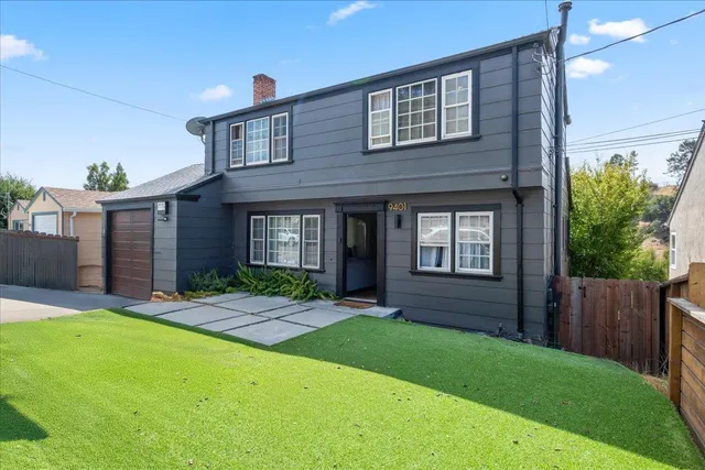 a view of a house with a yard and sitting area