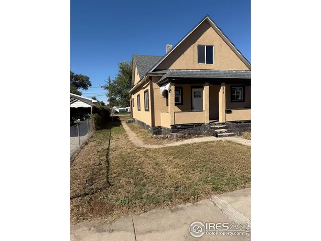 a view of a house with a small yard and wooden fence