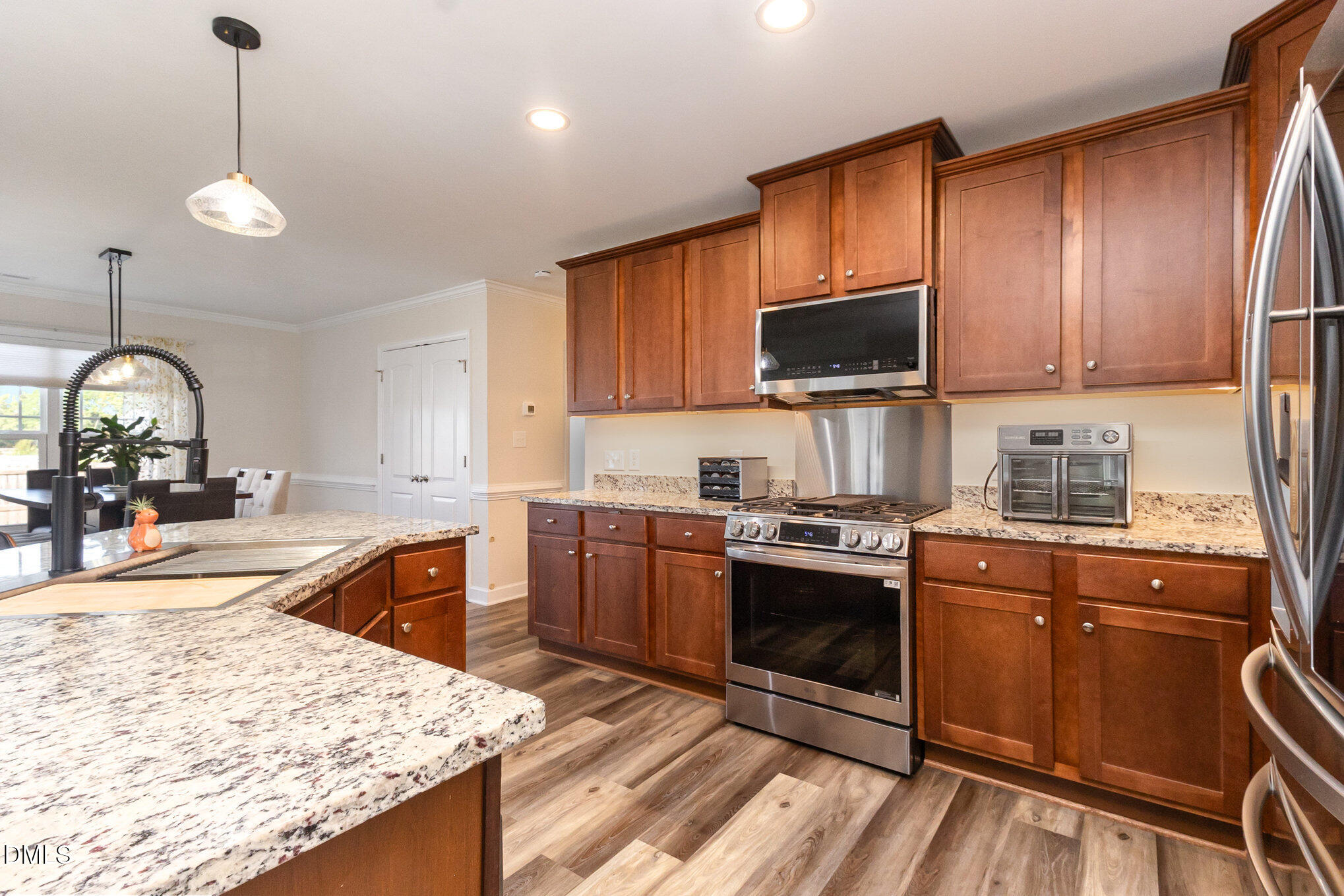 146 Wheat Drive Angier, NC 27501 - Photo 16 of 46 a kitchen with granite countertop wooden cabinets and a stove
