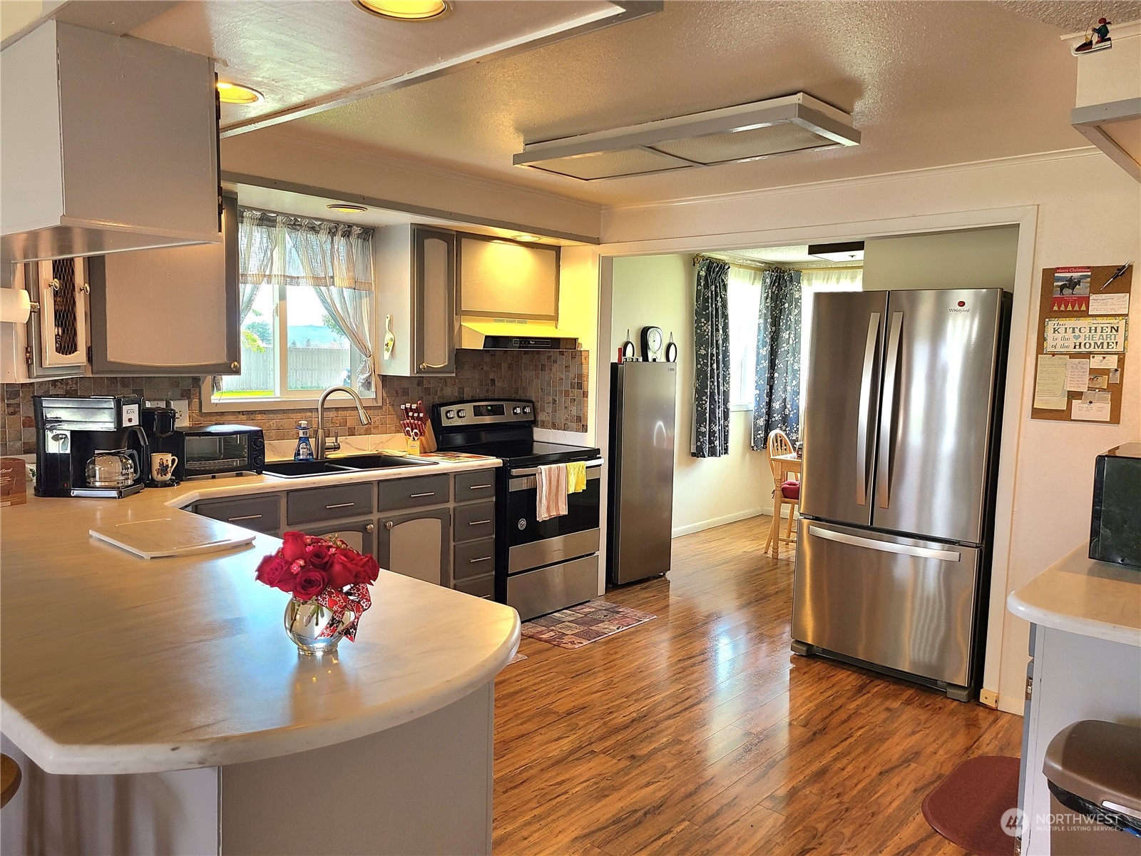 28 Robinson Canyon Road Omak, WA 98841 - Photo 20 of 33 a kitchen with stainless steel appliances granite countertop a refrigerator a sink dishwasher a stove and a dining table with wooden floor