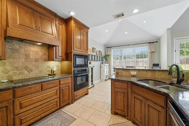 a kitchen with granite countertop stainless steel appliances and refrigerator