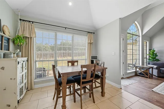 a dining room with stainless steel appliances a table and chairs in it