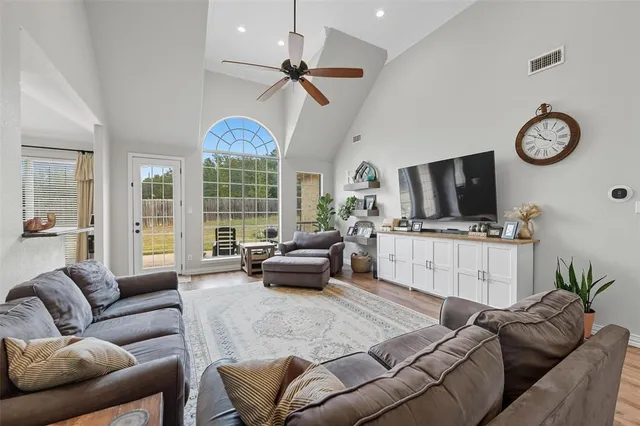 a living room with furniture ceiling fan and a large window